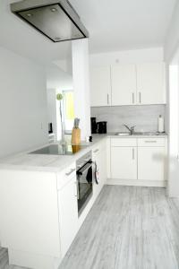 沙博伊茨Seeschwalbe的白色的厨房配有白色橱柜和水槽