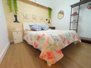 塞维利亚Apartamento para 3 en pleno centro de Sevilla的一间卧室配有一张带花卉床罩的床。