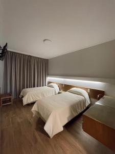 卡塔马卡HOTEL ARENALES的酒店客房设有两张床和窗户。