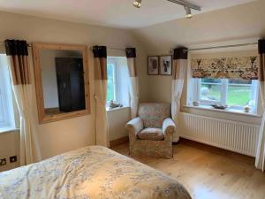 拉伊Stunning 2-Bed cottage Rye East Sussex的一间卧室配有一张床、一把椅子和窗户。