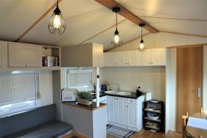帕塔亚什AquaHause的厨房配有白色橱柜和天花板上的灯。