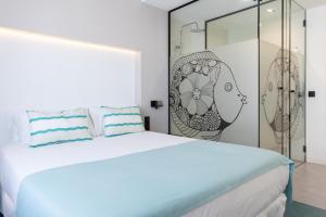 大加那利岛拉斯帕尔马斯Sercotel Puerto de la Luz的白色的卧室设有一张大床和玻璃墙