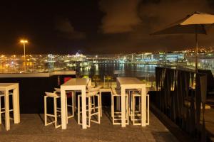 大加那利岛拉斯帕尔马斯Sercotel Puerto de la Luz的一群桌子和椅子在晚上在阳台上