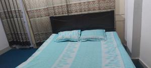 达卡Kompass Homestay - Affordable AC Room With Shared Bathroom in Naya Paltan Free WIFI的床上有2个蓝色枕头