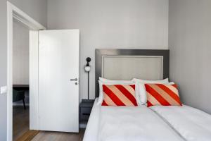 奥斯陆numa l Topp Apartments的一间卧室配有红色和白色枕头的床