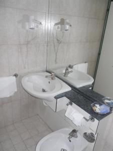 奇维塔韦基亚渡船酒店的白色的浴室设有两个盥洗盆和镜子