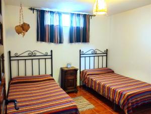 隆达La Casita de Piedra的一间卧室设有两张床和窗户。