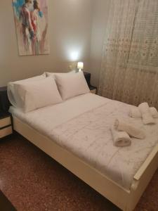干尼亚Dimitras residence的一张带白色床单和毛巾的床