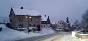 布赖滕布伦Zur alten Schmiede - Breitenbrunn/Erzgebirge的街上的房屋,地面上积雪