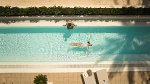 卡列罗港Secrets Lanzarote Resort & Spa - Adults Only (+18)的两个人在游泳池游泳