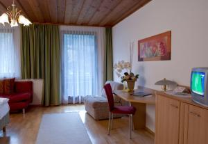 穆尔河畔布鲁克Gasthof Pichler的客厅配有书桌、沙发和电视