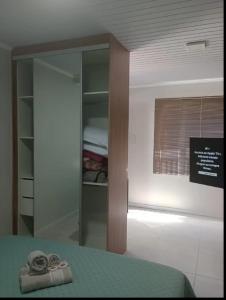 本图贡萨尔维斯LOFT DONA MARIA的一间卧室配有一张床和一个玻璃衣柜