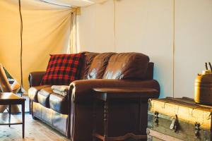 HillierFronterra Farm- Luxury Camp Experiences的客厅配有棕色皮沙发和桌子