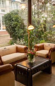 巴登-巴登易拓高级酒店的客厅设有两张沙发和一张带鲜花的桌子