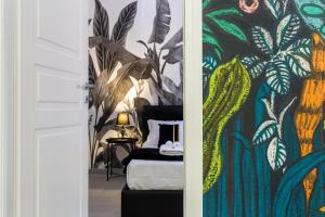 加利波利Tropical - Boutique Apartment的一间卧室配有一张床和植物壁画