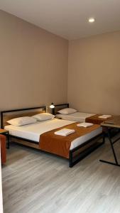 博尔若米Polifonia Inn Borjomi的客房设有两张床、一张书桌和一张书桌