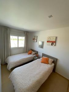 阿尔阿马德穆尔西亚Condado de Alhama Murcia的一间卧室设有两张床和窗户。