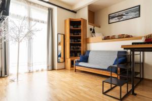 米兰LA CASA COLORATA - Flats in Milan - Bocconi的客厅设有蓝色的沙发和窗户。