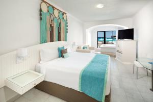 坎昆Cyan Cancun Resort & Spa的白色卧室设有一张大床和电视。