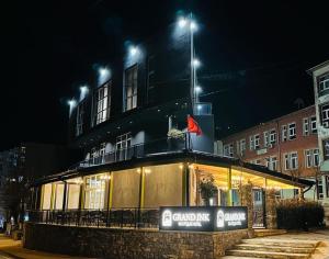 KukësGRAND JNK Boutique Hotel的一座晚上有灯的建筑