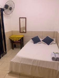 安格拉杜斯雷斯Hotel Pousada AngraAntiga的一间卧室配有一张白色的床、蓝色枕头和镜子