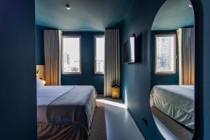 波尔图Regras 45 Building A by LovelyStay的蓝色的客房设有两张床和两个窗户。