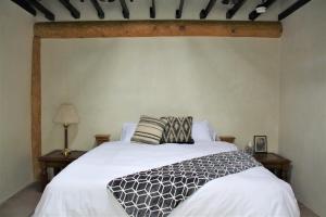 阿尔伯克基Casa Mijas - Main Historic House的一间卧室配有一张带白色床单的大床