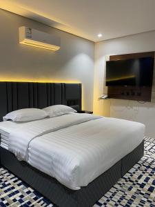艾卜哈قمم بارك Qimam Park Hotel 4的一间卧室设有一张大床和一台平面电视。