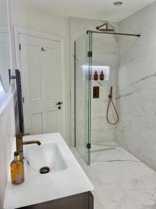 鲍内斯温德米尔Heather Mere Cottage, Bowness-on-Windermere的带淋浴和盥洗盆的白色浴室