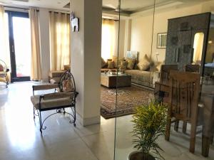 新德里Avatar Living@ Greater Kailash 2的客厅配有沙发和桌子
