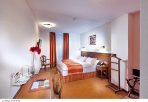 洛桑阿拉加里酒店的配有一张床和一张书桌的酒店客房