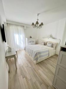 伊斯基亚Maison Mele Ischia的白色卧室配有一张床和一个吊灯