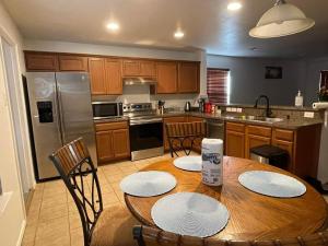 达拉斯Private room in Dallas的厨房配有带椅子的木桌,厨房配有不锈钢用具
