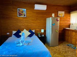 圣拉蒙Bungalows Yakari Grei的一间卧室配有一张蓝色的床和一台冰箱