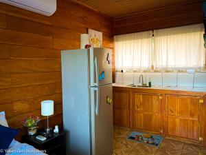 圣拉蒙Bungalows Yakari Grei的带木制橱柜的厨房内的白色冰箱