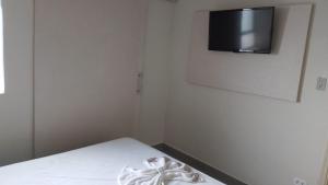 普鲁登特总统城HOTEL ITAVERÁ BRASIL的卧室配有一张床铺,墙上配有电视