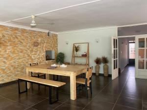 科托努L'Oasis Guesthouse的一间设有木桌和砖墙的用餐室