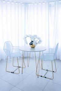 布卡拉曼加Street 55 Hotel的一张带两把椅子的白色桌子和花瓶