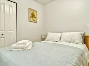 伯纳比Burnaby Metrotown Cozy 3 Bedroom Suite的一间卧室配有一张带白色床单的大床