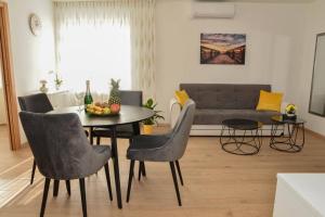 扎达尔Apartment Longin的客厅配有桌椅和沙发
