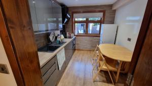 爱丁堡Self-catering extended family home的厨房铺有木地板,配有木桌。