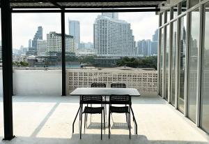 曼谷River Home Bangkok的市景阳台的桌椅