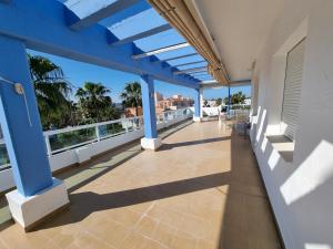 科斯塔巴伦娜Ático en Costa Ballena con Barbacoa, Aire Acondicionado y WIFI的阳台设有蓝色柱子,享有海洋美景。