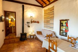 El Pinar del HierroCasa rural La Jarita的带沙发和燃木炉的客厅