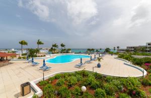 LowlandsRoyal Islander Club Resort La Terrasse的一个带椅子的游泳池,背景是大海