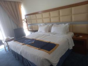 麦地那Emaar Elite Al Madina Hotel的酒店客房配有一张带白色床单和枕头的大床。