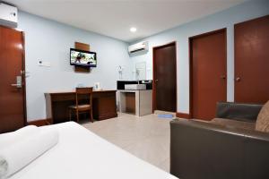 吉隆坡ORKID Hills at Pudu的一间卧室配有一张床、一张书桌和一台电视