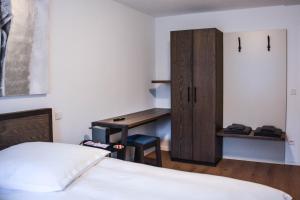 埃兴Hotel Pame Grill的一间卧室配有书桌、一张床和一个橱柜