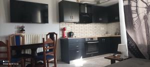 米里纳Αλέξανδρος 6的厨房配有黑色橱柜和炉灶烤箱。