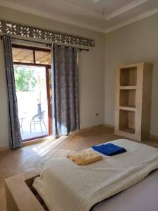 基济姆卡济Villa Pumziko的一间卧室设有一张大床和一个大窗户